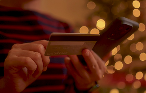 A person holding a bank card and a phone